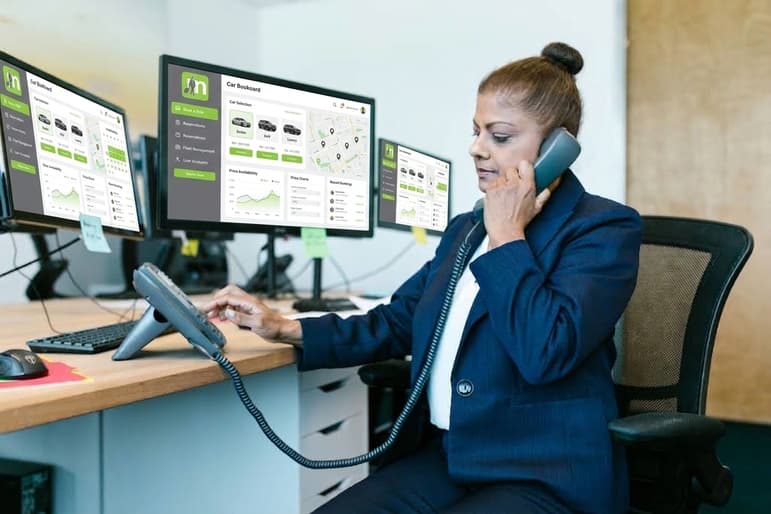 A transport company dispatcher managing bookings and fleet data across multiple screens